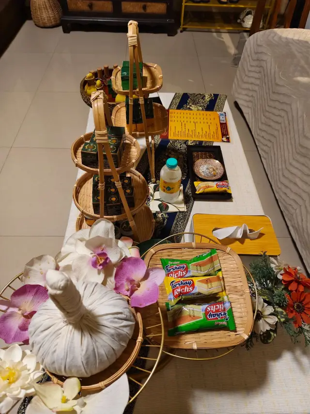 Herbal compress, plumeria flowers and snacks displayed on a tiered tray in the shop lounge