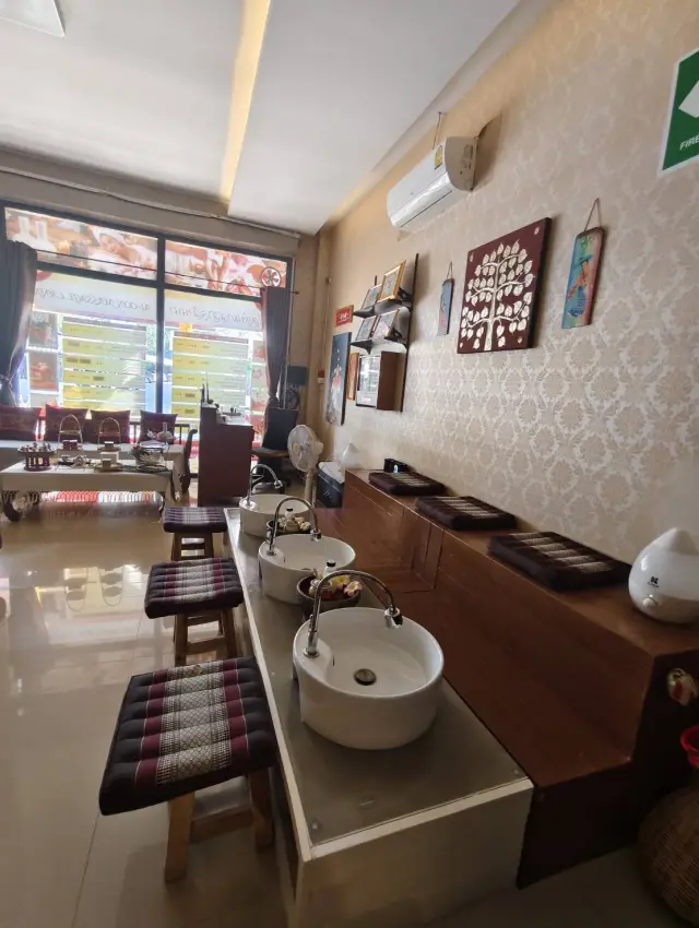Long foot-wash counter with stools and a window at Ai Oon Massage Lanna, Chiang Mai