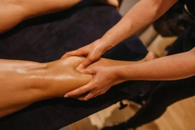 Therapist's hands massaging a guest's calf during a leg massage at Ai Oon Massage Lanna