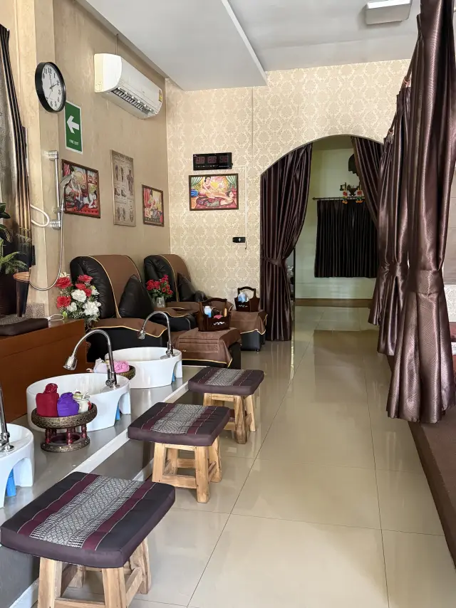Foot-wash basins, stools and recliners near an arched doorway at Ai Oon Massage Lanna