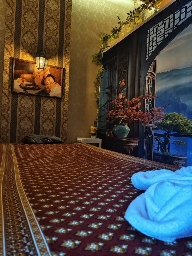 Thai massage room with a patterned floor mat and a blue towel at Ai Oon Massage Lanna