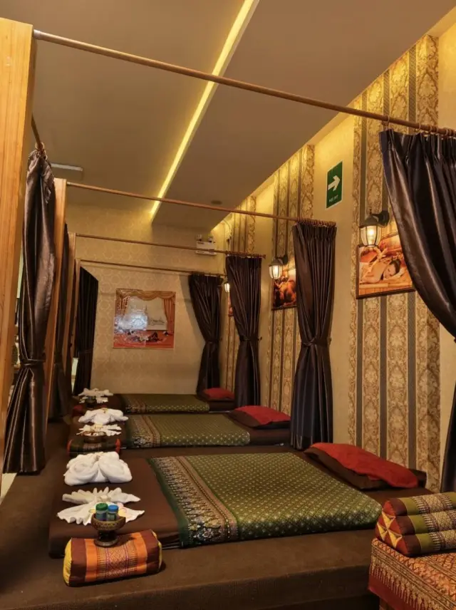 Curtained Thai massage mats with towels and cushions at Ai Oon Massage Lanna, Chiang Mai