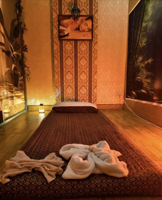 Thai massage mat with rolled towels in a softly lit room at Ai Oon Massage Lanna