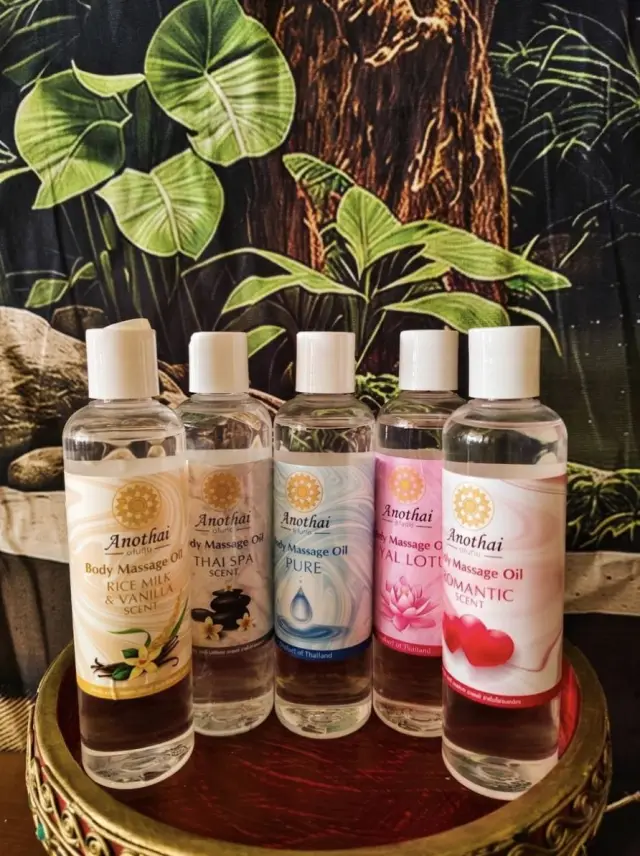 Five bottles of body massage oil in different scents displayed on a tray at Ai Oon Massage Lanna