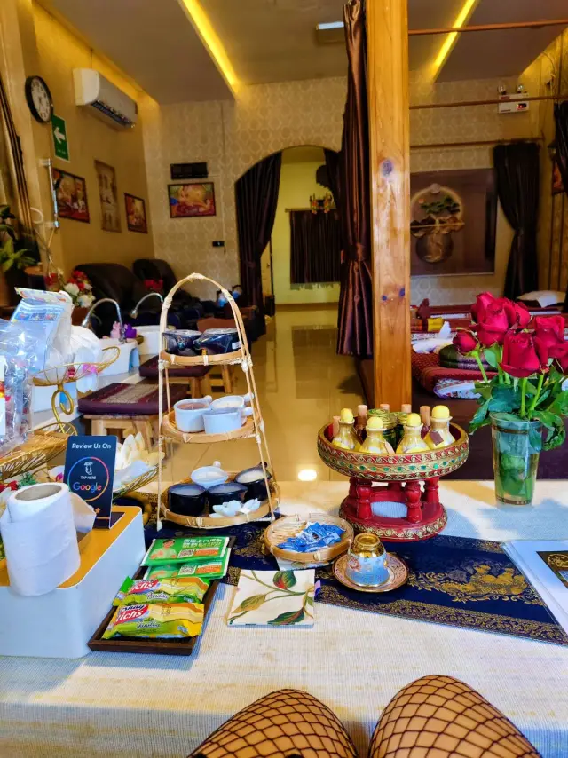 Refreshment table with snacks, flowers and a tiered tray in the lounge at Ai Oon Massage Lanna