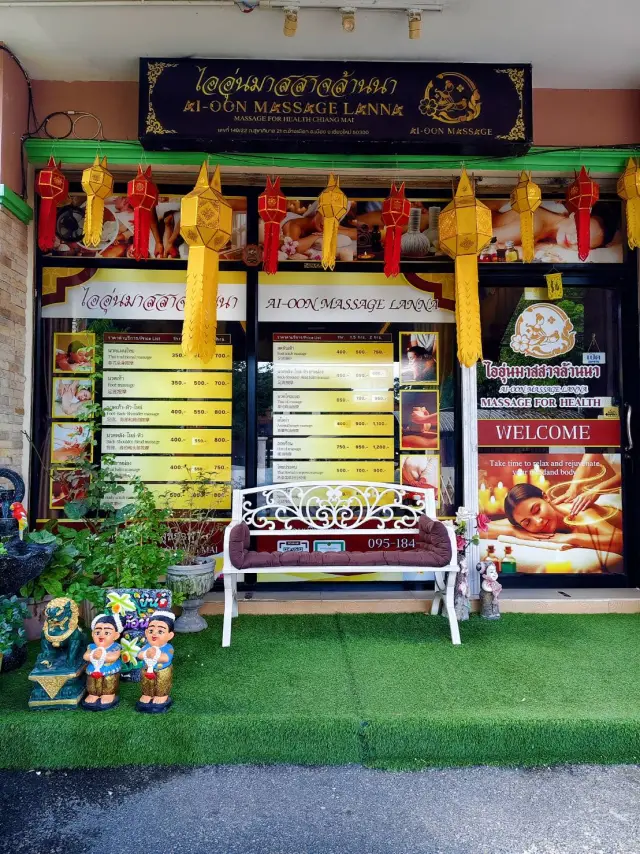 Front of Ai Oon Massage Lanna with hanging Lanna lanterns, price boards and a bench in Chiang Mai