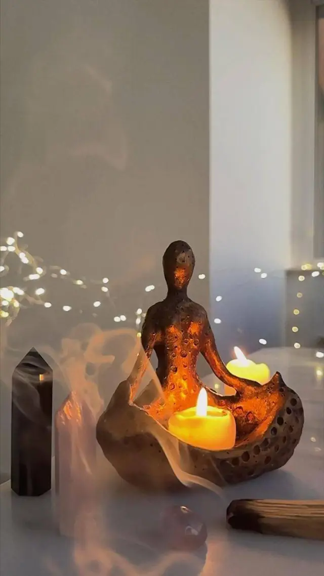 Candle holder with a small meditating figure for a relaxing atmosphere in the massage shop