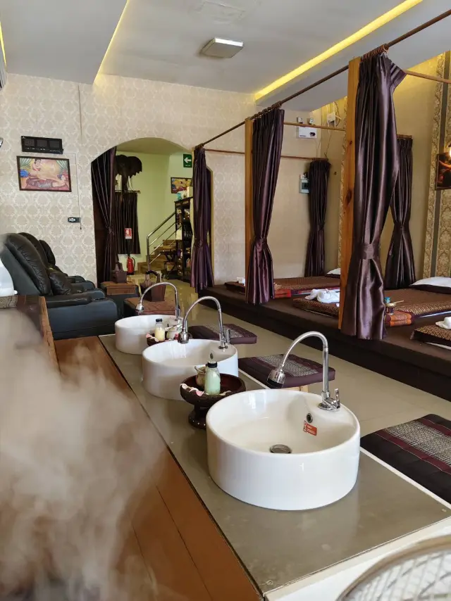 Foot-wash basins with rising steam beside the Thai massage mats at Ai Oon Massage Lanna